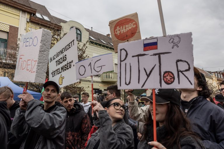22 March 2026, Hódmezővásárhely, Hungary. FIDESZ election rally. FIDESZ supporters were accompanied by counter-demonstrators, supporters of the opposition TISZA party. They held numerous banners: ‘PEDO FIDESZ’ – suggesting links between FIDESZ members and paedophilia, ‘PUTYOR’ – meaning that Orbán is Putin’s man, ‘O1G’ – a code for the vulgar slogan “Orbán is a …” and “ФИДЕС” – FIDESZ written in Cyrillic. Counter-demonstrators are always quickly joined by people carrying a banner with an arrow pointing at the protesters and the slogan “This is the so-called ‘TISZA intelligentsia’."