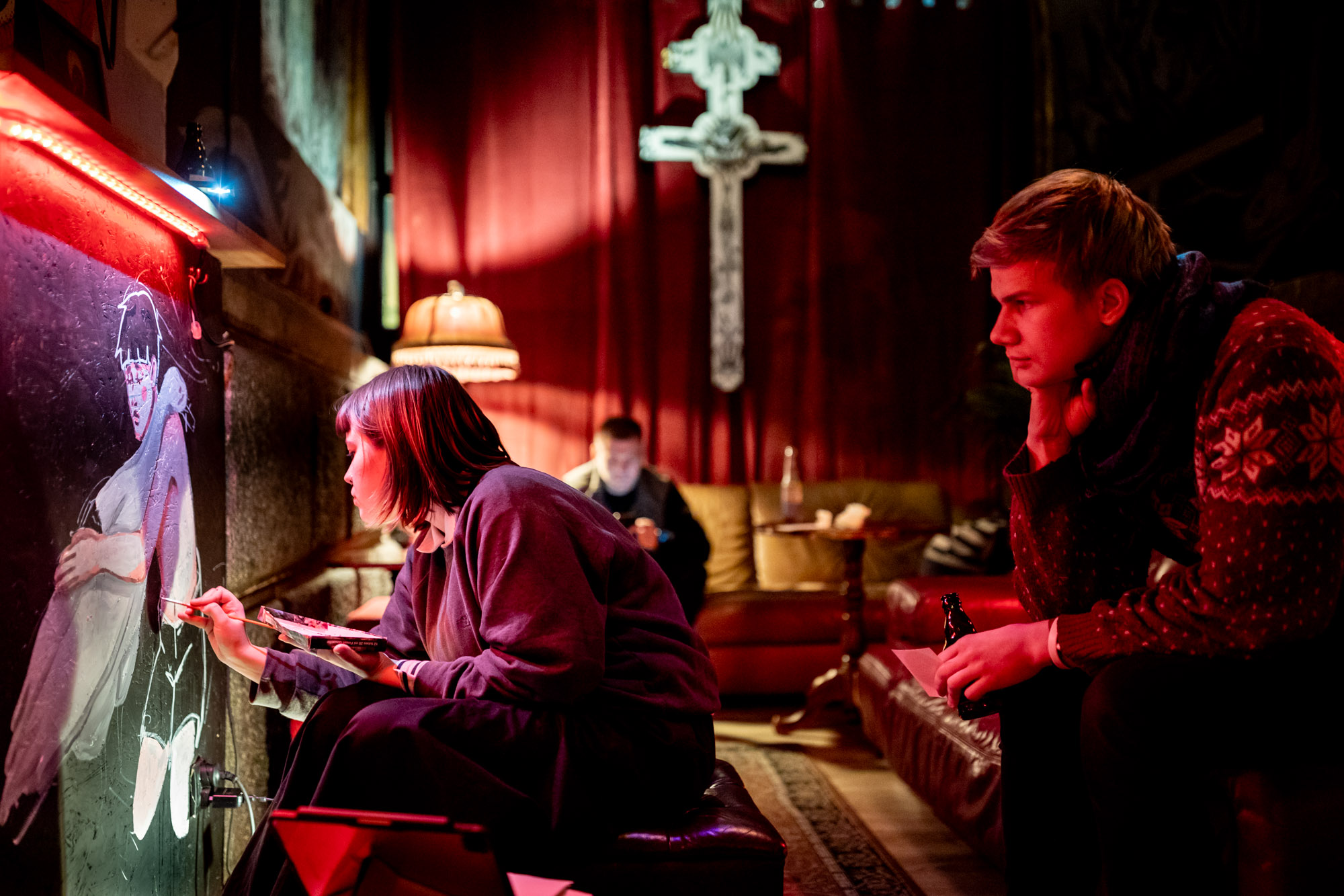 5 December 2022, Warsaw, the Belarusian bar Karma. Belarusian artist Paulina Demidowicz is painting a boy with a swan on the bar’s wall.